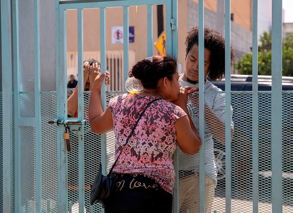 A Central American migrant looks on from a fence of Madre Assunta Institute