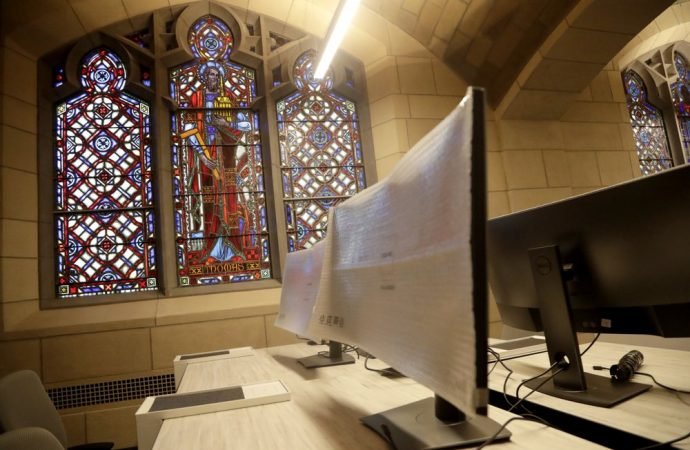 In this photo taken May 1, 2019, standing desks are alongside stained glass windows at the Audible offices in Newark, N.J. Audible's Newark offices are at the old Second Presbyterian Church. (Julio Cortez/AP via Crux)