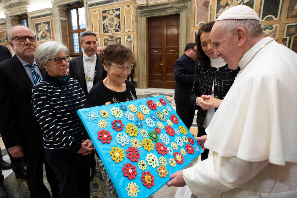 Pope Francis receives a gift from a member of the board of directors of Italy's pro-life movement during a Vatican audience Feb. 2