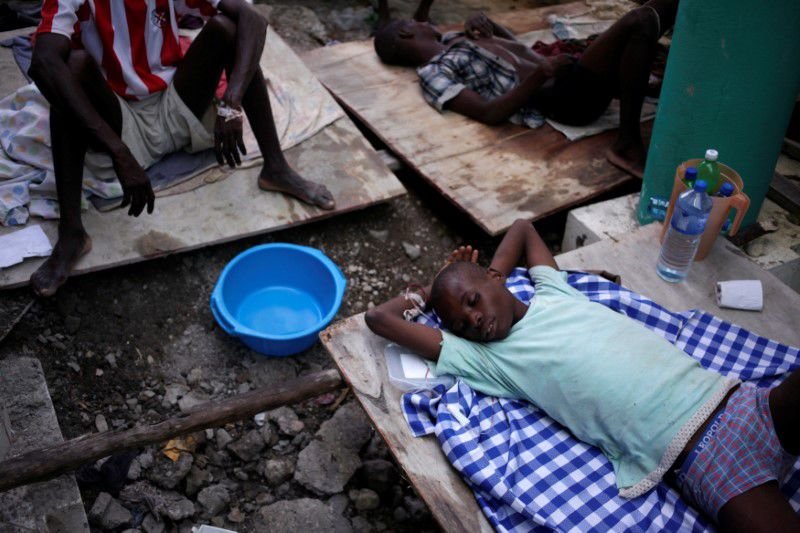 A boy rests at a makeshift hospital while receiving treatment for cholera after Hurricane Matthew swept through Port-a-Piment