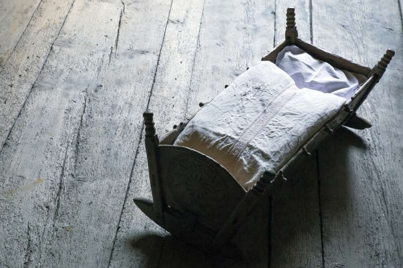 Empty wooden crib. Image via Shutterstock