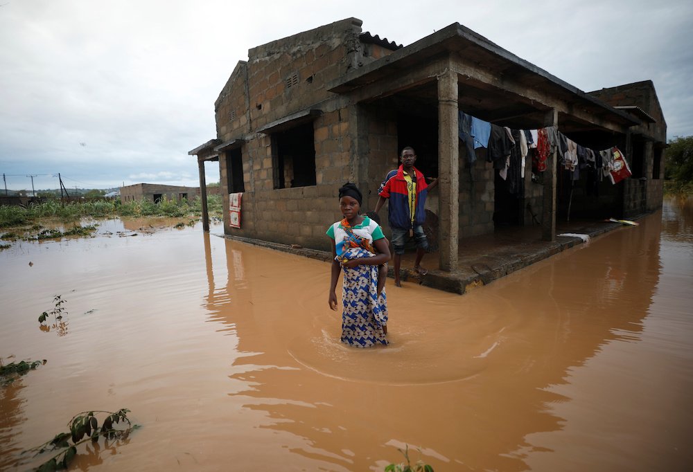 Agiro Cavanda and his wife, Agera, wade through floodwaters outside their home in Pemba, Mozambique, April 29, 2019, in the aftermath of Cyclone Kenneth. (CNS photo/Mike Hutchings, Reuters) See MOZAMBIQUE-REUNITE-CYCLONES May 7, 2019.