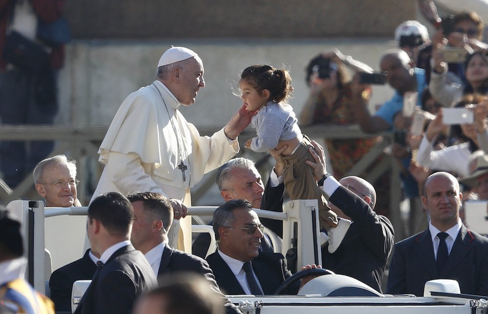 Pope Francis greets a child during his general audience in St. Peter's Square at the Vatican Oct. 10. (CNS photo/Paul Haring)