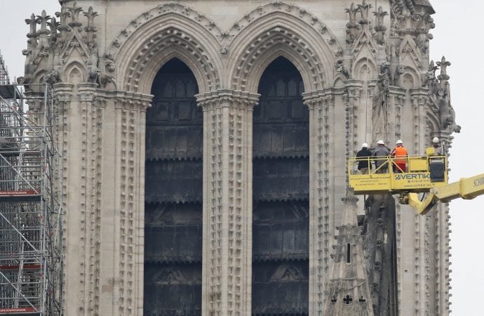 A crane lifts experts as they inspect the damaged Notre Dame cathedral after the fire in Paris