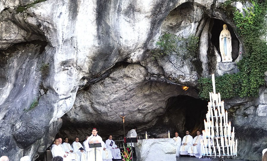 Mass in the grotto at the Shrine of Our Lady of Lourdes in France.