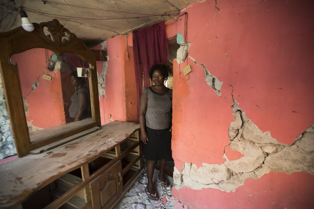 A woman walks amid the debris of her house that was destroyed after an Oct. 6 earthquake in Gros Morne