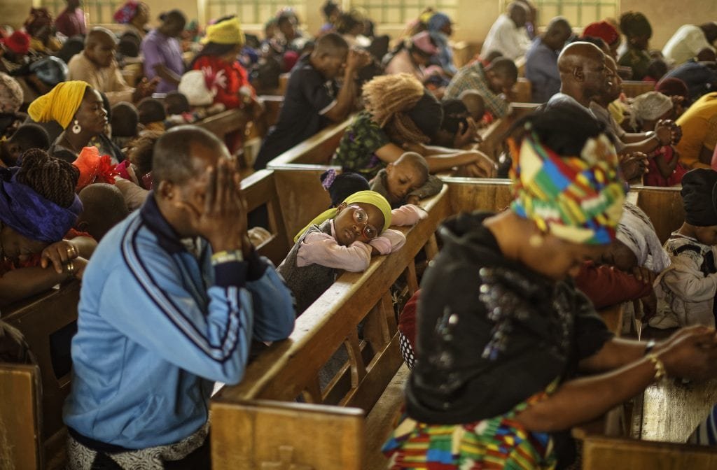 Churchgoers pray during a morning service at the Saint Charles Catholic Church