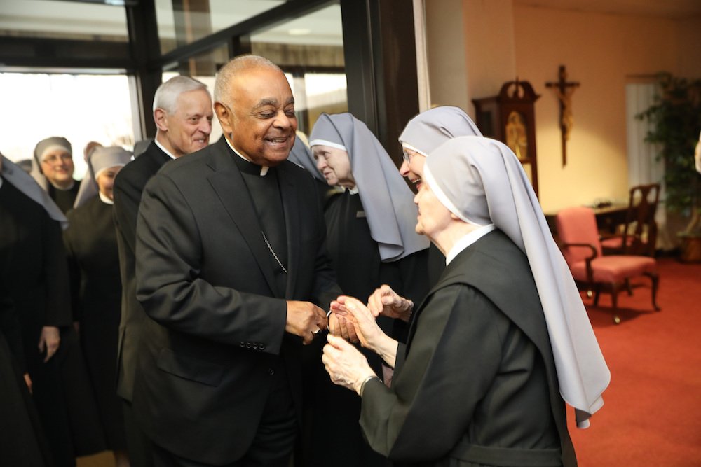 Archbishop Wilton D. Gregory greets a Little Sister of the Poor at the Jeanne Jugan Residence the order operates for the elderly poor in Washington April 5