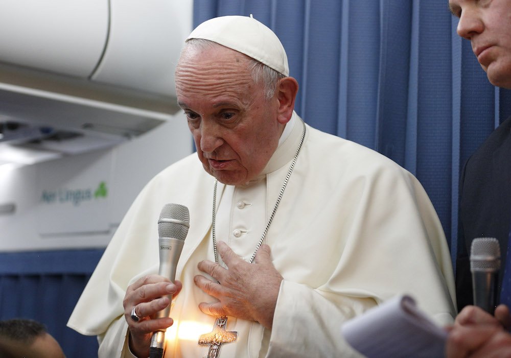 A shaft of light illuminates Pope Francis as he responds to a question from reporter Anna Matranga of CBS News aboard his flight from Dublin to Rome Aug. 26. Matranga asked the pope about a statement made by Italian Archbishop Carlo Maria Vigano