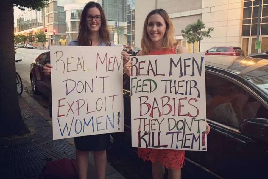 Kate Bryan and her friend display the signs they held at a Sept. 26 Men for Choice rally in Washington