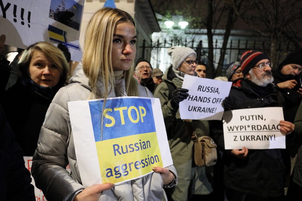 People gather to protest in front of the embassy of the Russian Federation Nov. 26 in Warsaw