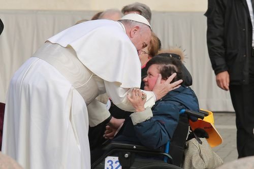 Pope Francis embraces an individual with disabilities at the general audience in St. Peter's Square
