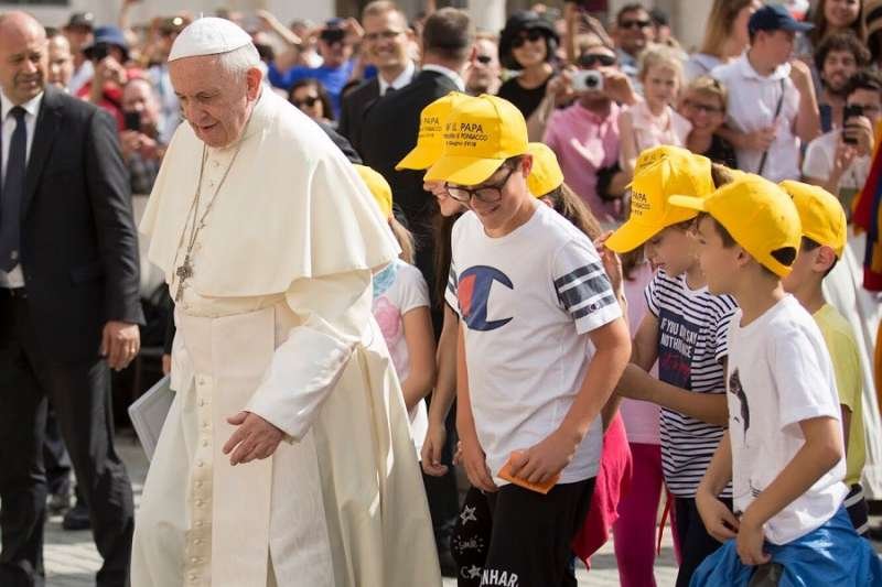 Pope Francis walks with young people during his general audience June 13
