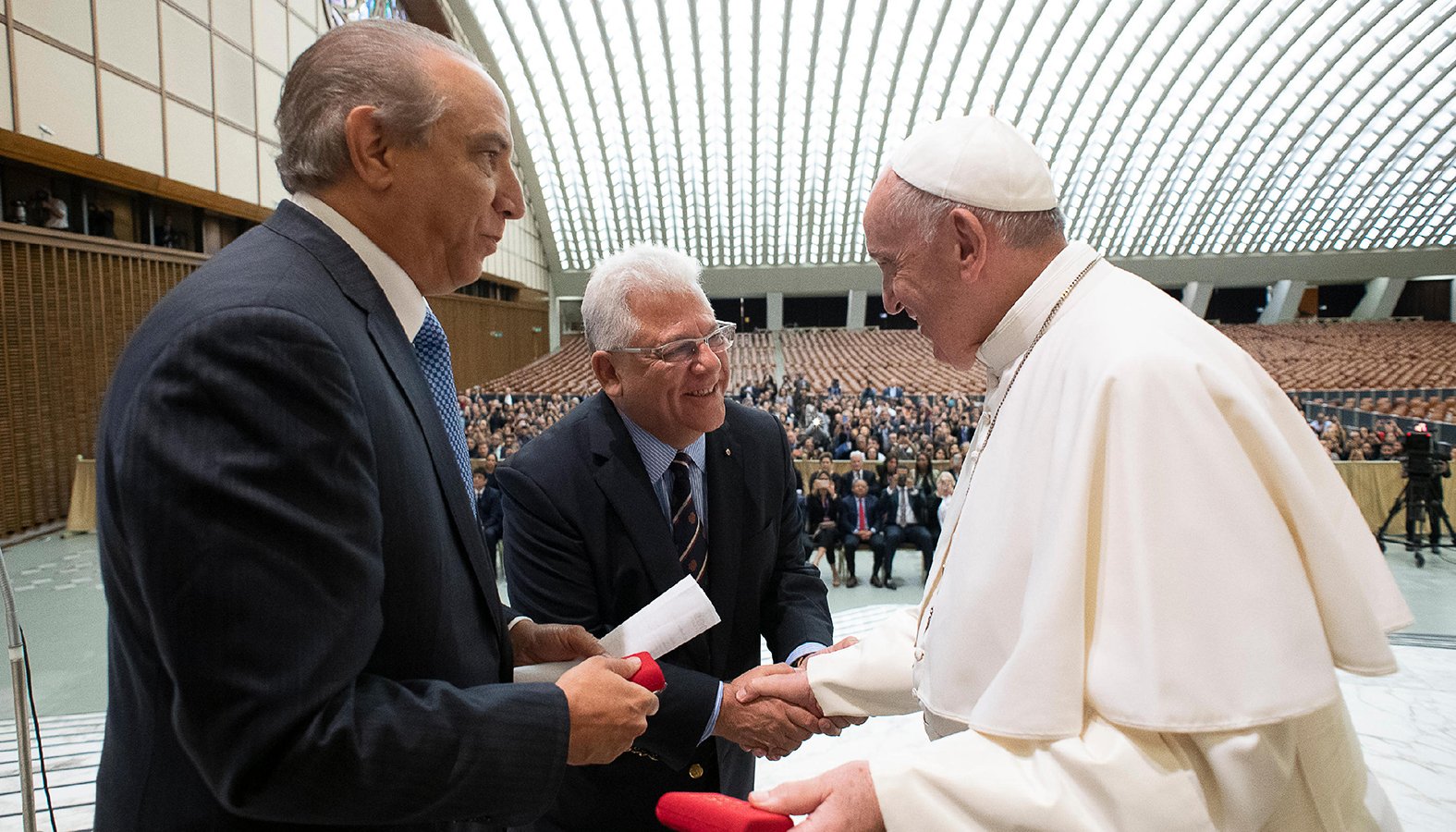 Pope Francis greets Dr. Ramon Tallaj, founder and chairman of the board of Somos Community Care, and Mario J. Paredes, chief executive officer, during a Sept. 20, 2019, symposium at the Vatican on the health care needs of immigrants. (CNS photo/Vatican Media)