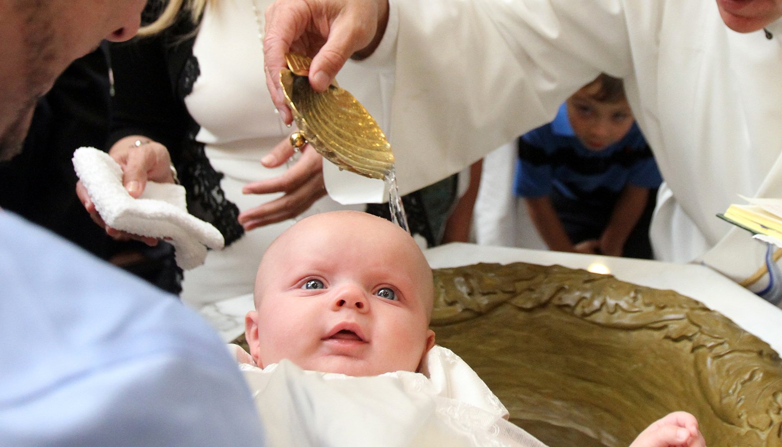 A baby is seen during her baptism. France's Catholic bishops criticized legislation to allow medically assisted procreation for single mothers and lesbian couples and urged citizens to help block its enactment. (CNS photo/Gregory A. Shemitz)