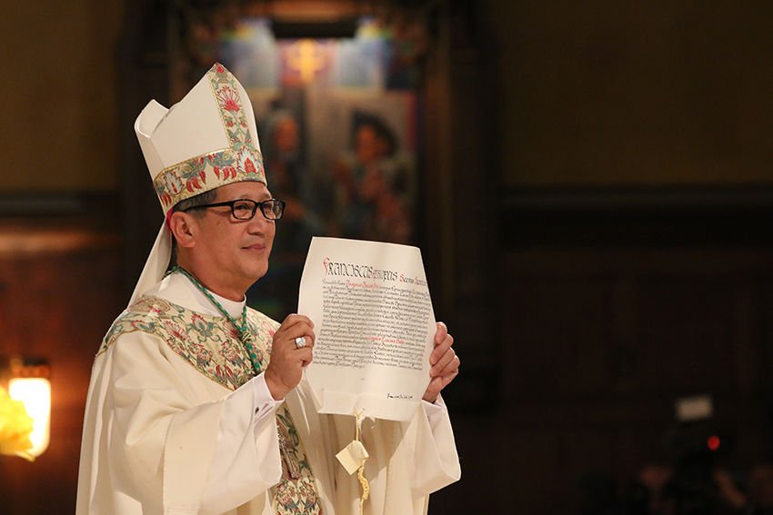 Bishop Oscar A.Solis displays his apostolic mandate from Pope Francis during his installation Mass as the bishop of the Diocese of Salt Lake City on March 7