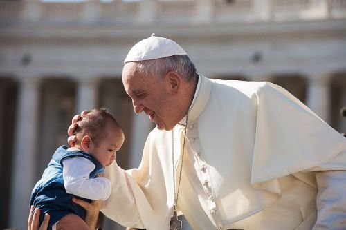 Pope Francis embraces a baby during the general audience in St. Peter's square on Aug. 26