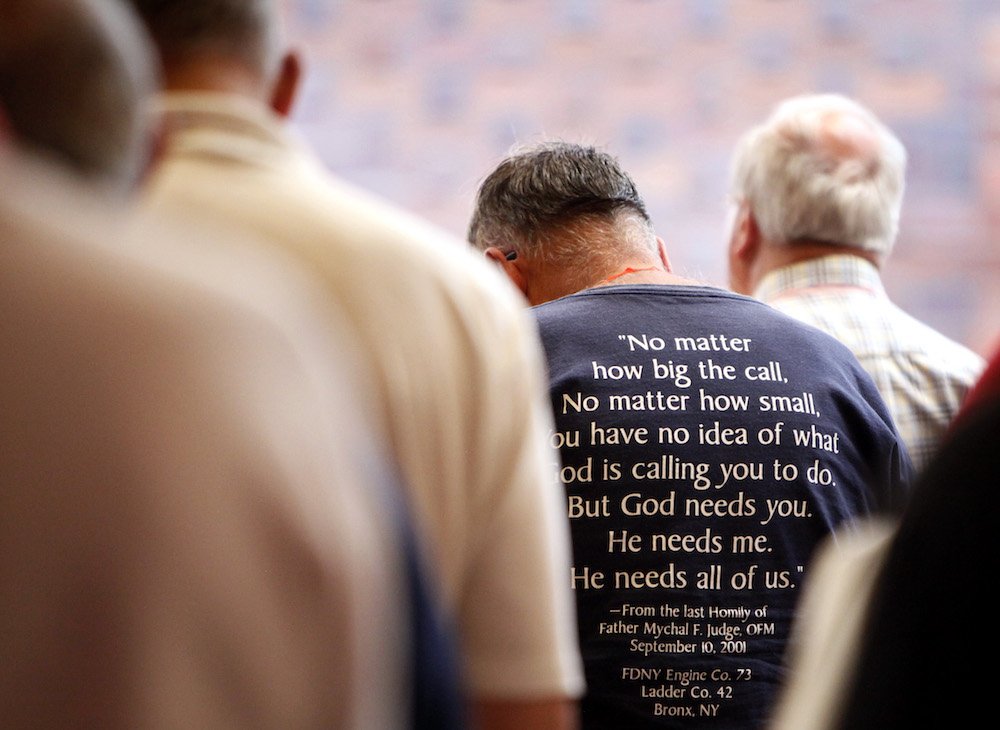 Members of the Association of U.S. Catholic Priests bow their heads in prayer at a Mass during the organization's gathering in Chicago in 2016. (CNS photo/Karen Callaway