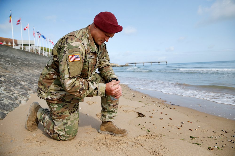 A U.S. Army soldier collects sand June 3