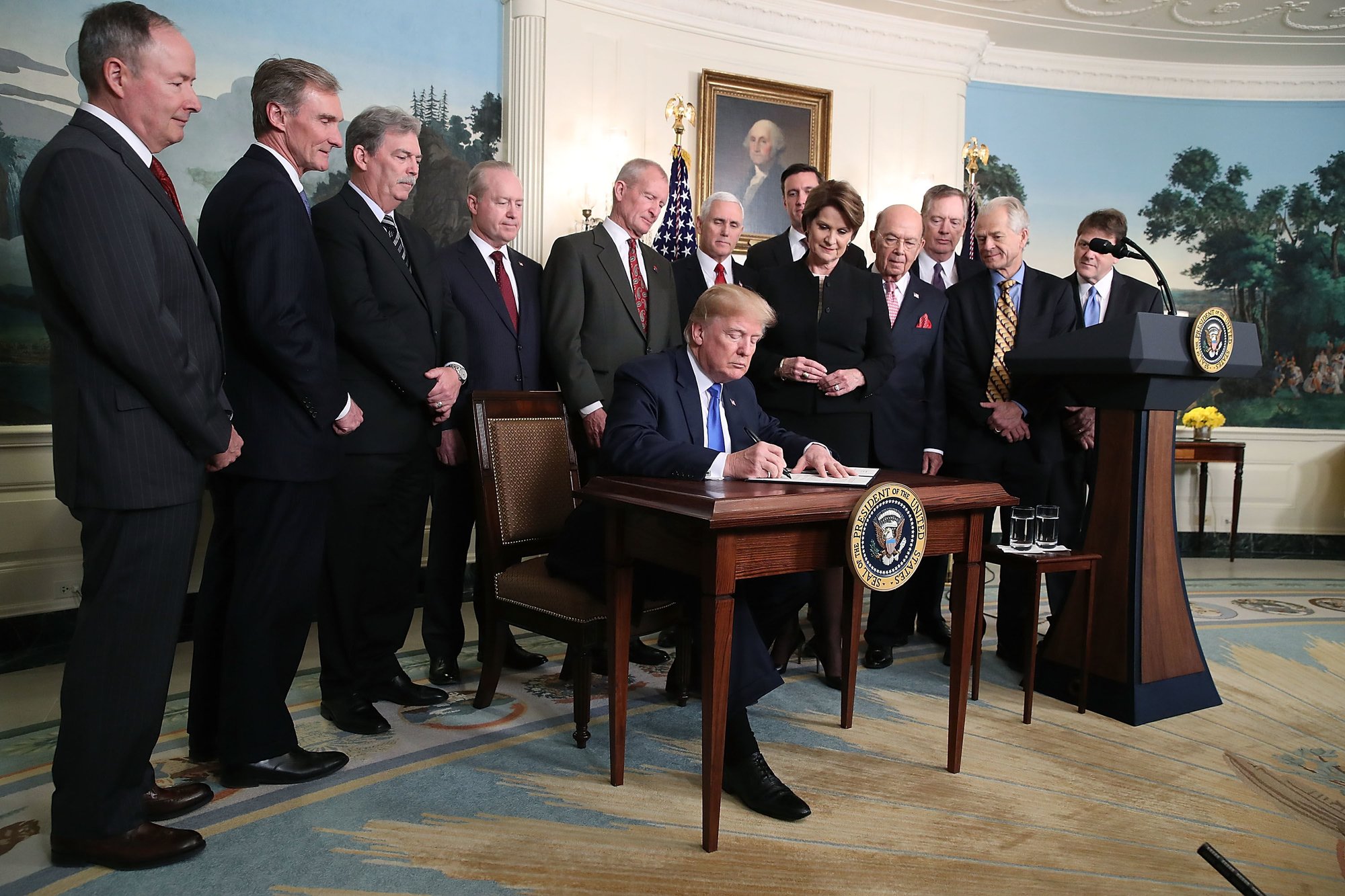 President Donald Trump is flanked by members of the business community as he signs a presidential memorandum aimed at what he calls Chinese economic aggression in the Roosevelt Room at the White House on March 22