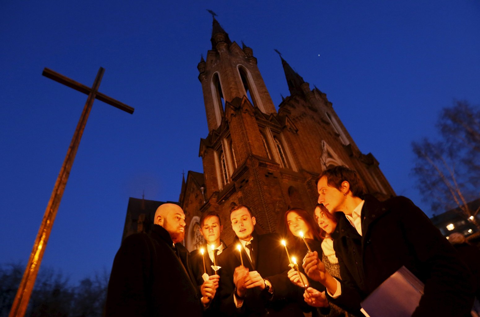 People light candles in front of a Catholic church during the Easter vigil in the Siberian city of Krasnoyarsk