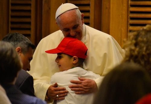 Pope Francis embraces a young student on May 31