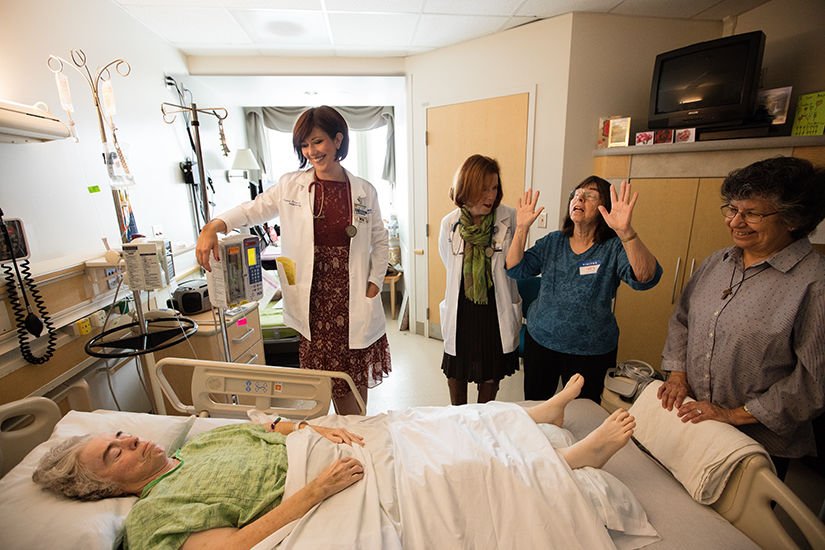 Nurse Rebekah Riemer and nurse manager Marianne Ayala gather around patient Linda Ficher with relatives. (photo/Victor Aleman)