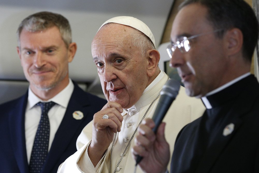 Pope Francis is pictured as he greets journalists aboard his flight from Rome to Maputo