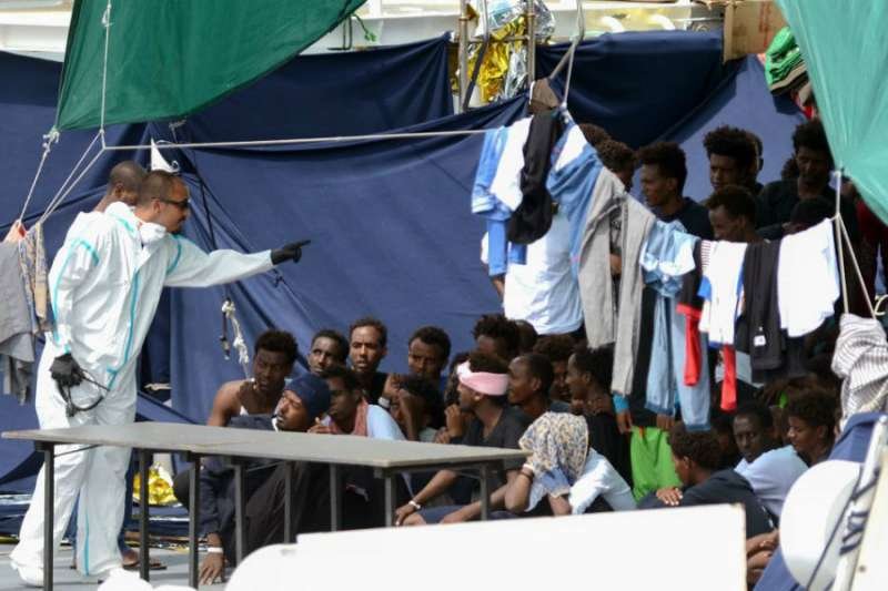 Migrants on the the Italian Coast Guard vessel Diciotti wait to embark. Credit: Giovanno Isolino/AFP/Getty Images.