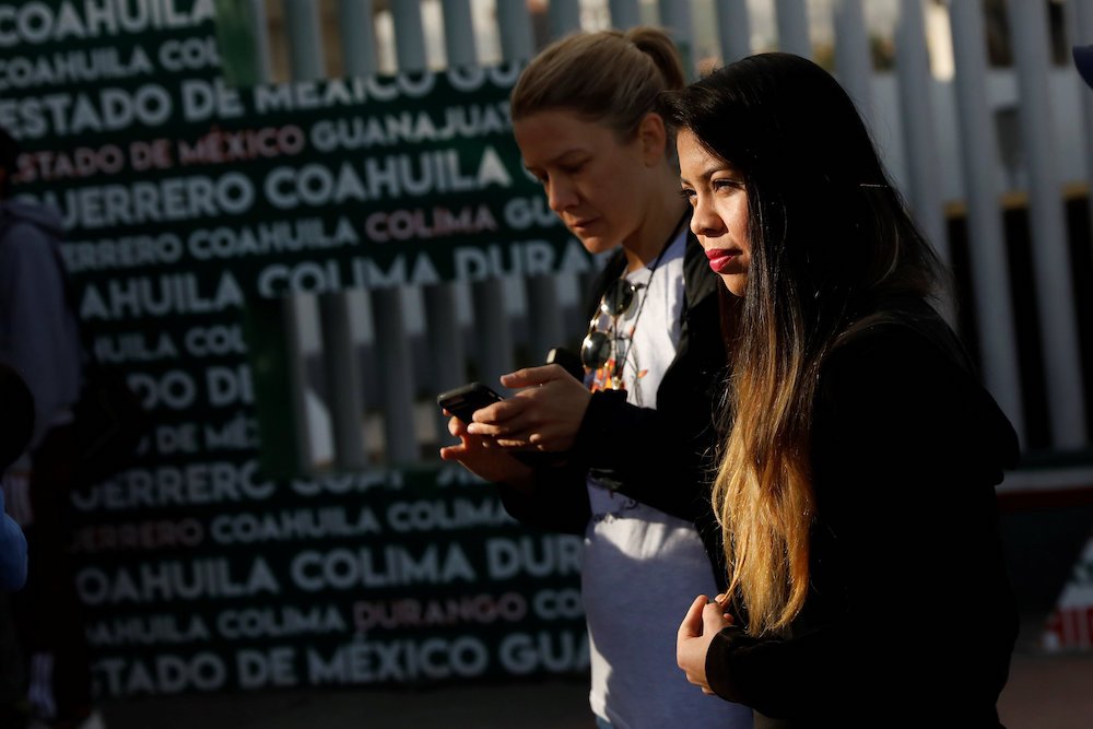 A woman waits for her number to seek asylum in the United States at the Chaparral border crossing in Tijuana