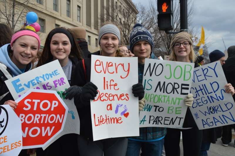 Young people hold signs opposing abortion during the March for Life in Washington