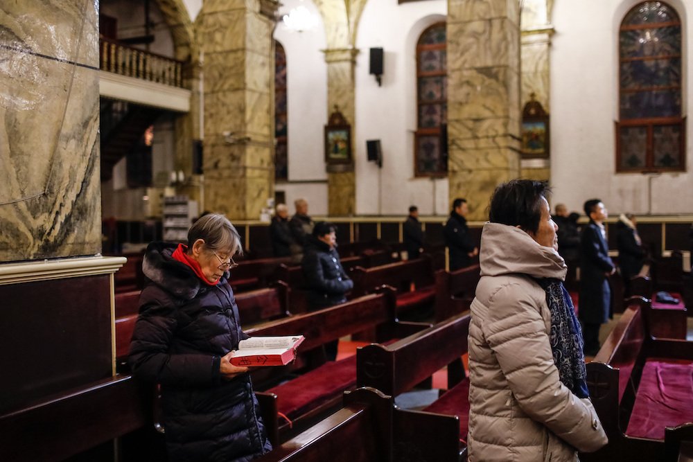 Chinese Catholics pray during Mass in late January inside the Cathedral of the Immaculate Conception in Beijing. As part of its ongoing efforts to reconcile China's Catholic communities