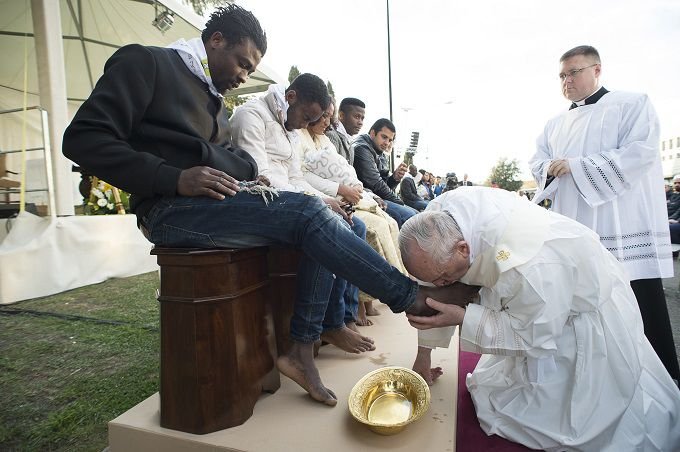 Pope Francis washes the feet of migrants and refugees during Holy Thursday Mass March 24