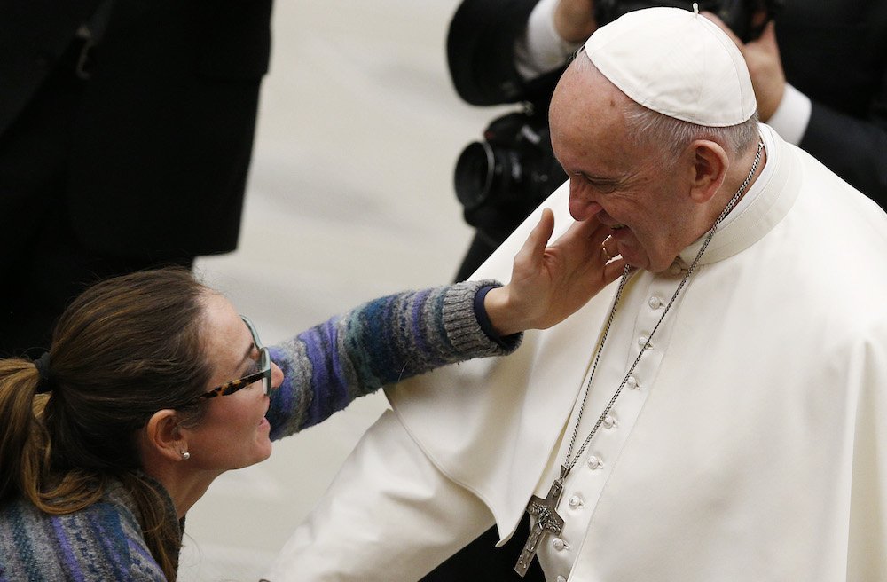A woman touches Pope Francis' face during his general audience in Paul VI hall at the Vatican Jan. 16. (CNS photo/Paul Haring)