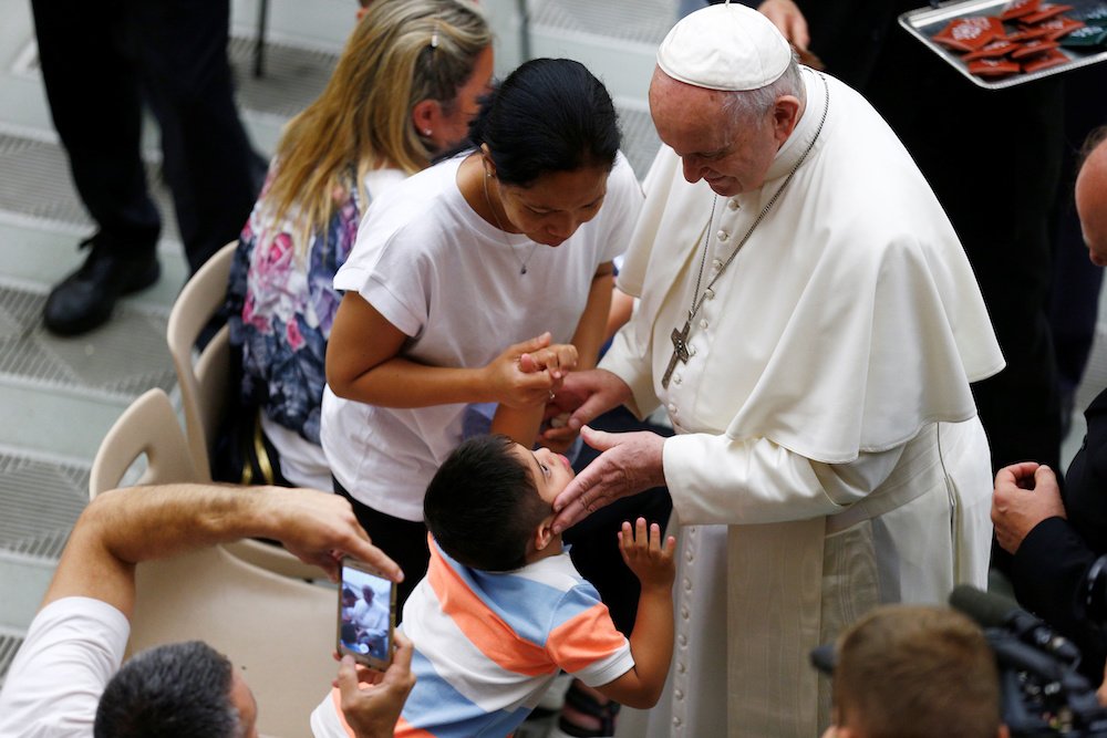 Pope Francis greets a child during his general audience in Paul VI hall at the Vatican Aug. 7