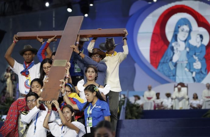 Venezuelan youth hold up a cross during a Station of the Cross performance lead by Pope Francis