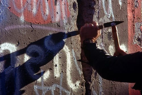A West German man uses a hammer and chisel to chip off a piece of the Berlin Wall as a souvenir in November 1989 (Credi: U.S. Department of Defense).