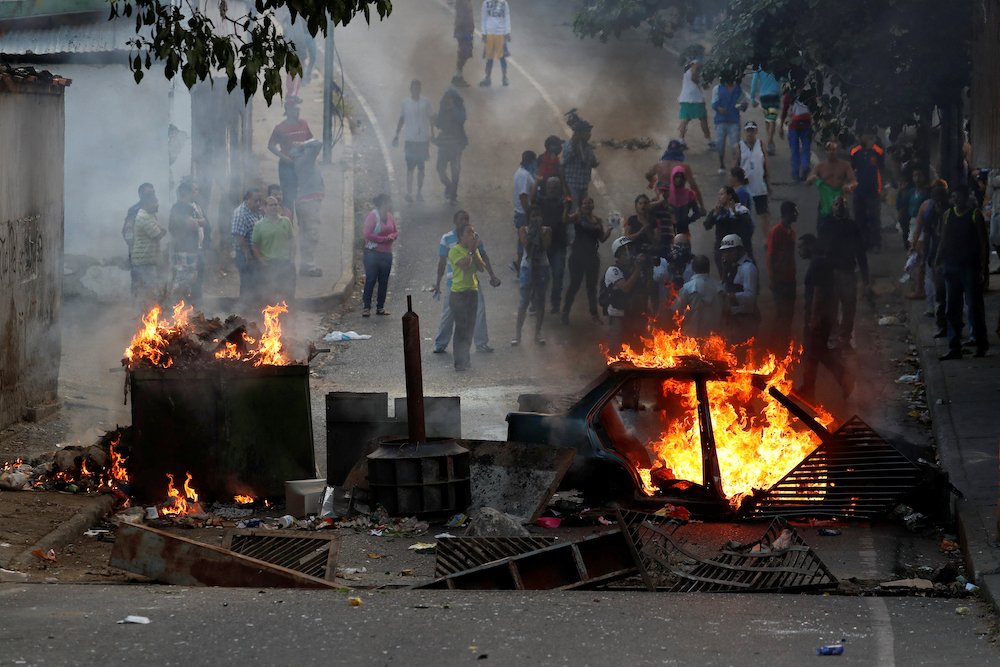 Demonstrators stand behind a burning barricade Jan. 21
