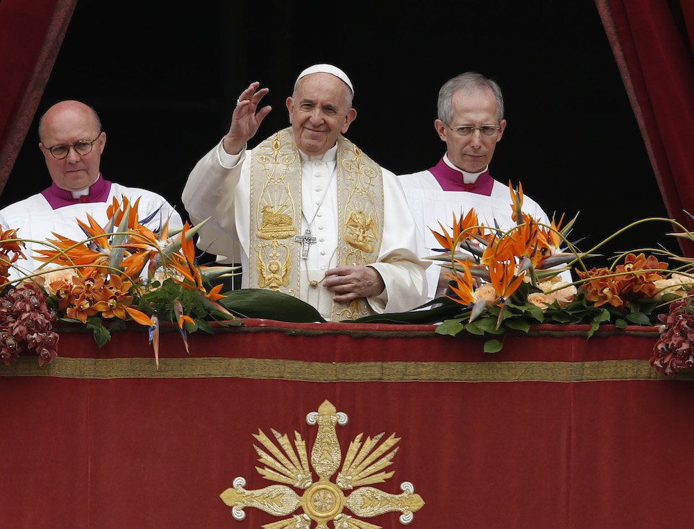 Pope Francis greets the crowd during his Easter message and blessing "urbi et orbi" (to the city and the world) from the central balcony of St. Peter's Basilica at the Vatican April 21