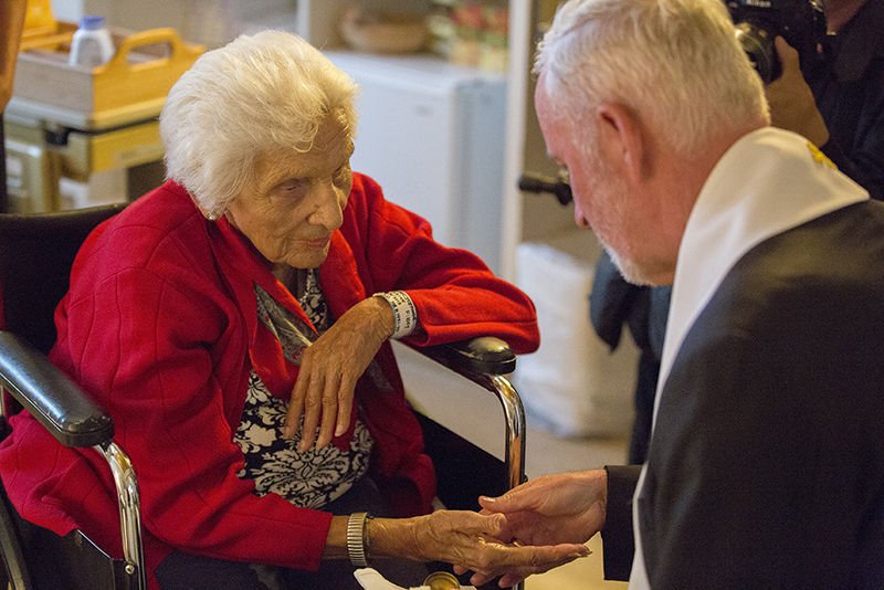 AuxiliaryBishop O'Connell comforts a woman at Sata Teresita