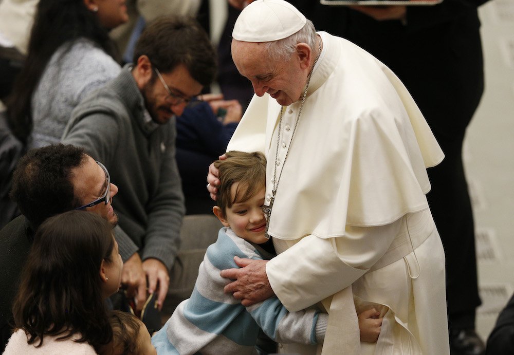A boy embraces Pope Francis during his general audience in Paul VI hall at the Vatican Jan. 9. (CNS photo/Paul Haring)