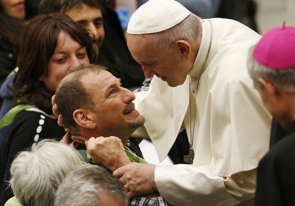 Pope Francis greets a man as he meets the disabled during his general audience in Paul VI hall at the Vatican Dec. 5. (CNS photo/Paul Haring)
