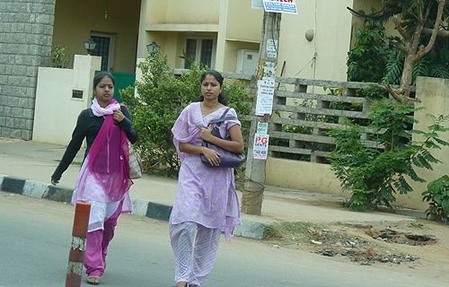 Young women walk along a street in Bangalore