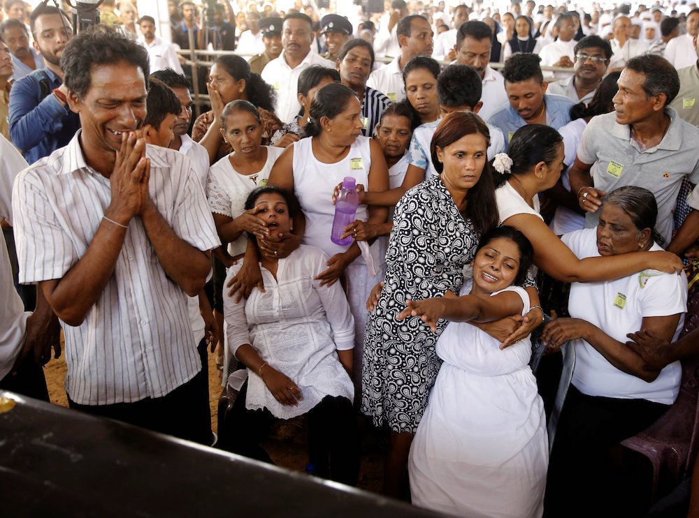 People mourn during a funeral Mass for victims in Negombo