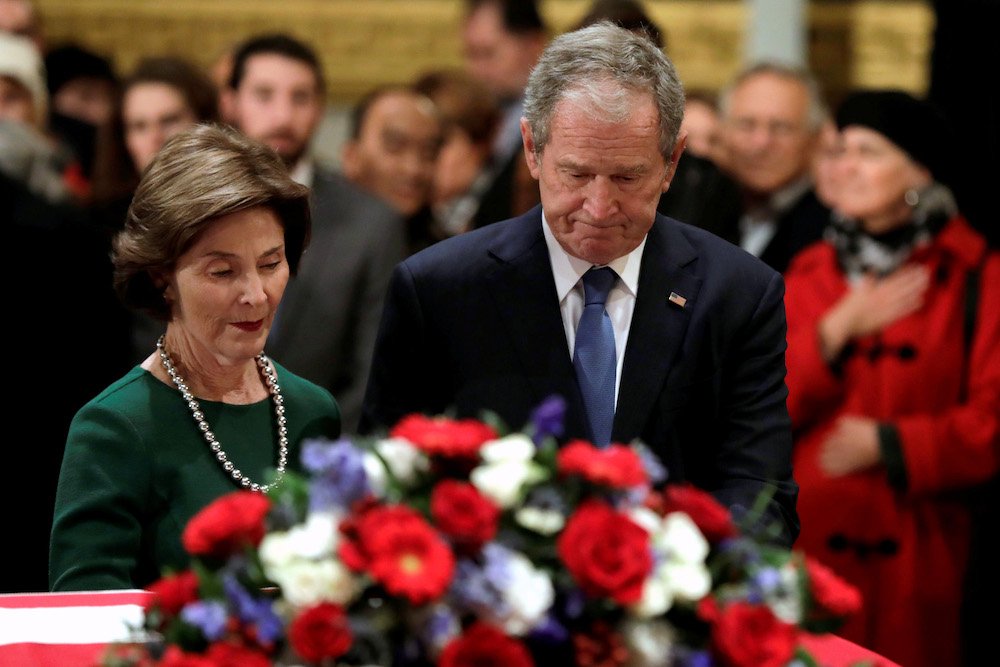 Former U.S. President George W. Bush and former first lady Laura Bush stand at the flag-draped casket of former U.S. President George H.W. Bush as he lies in state inside the U.S. Capitol rotunda Dec. 4 in Washington. George H.W. Bush