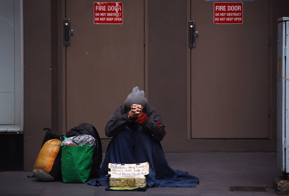 A homeless man begs for money on a street in Sydney Oct.14