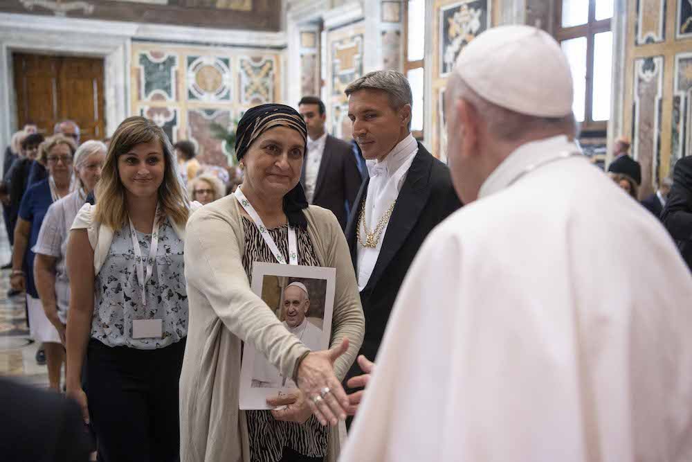 Pope Francis greets an attendee during a meeting with doctors