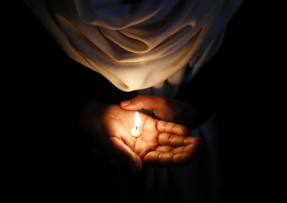 A Christian in New Delhi holds a candle during a solidarity vigil March 16