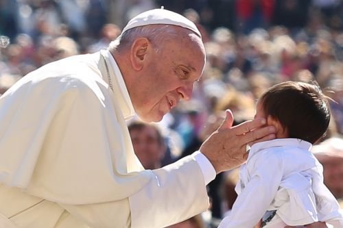 Pope Francis kisses a child in St. Peter's Square during the General Audience on April 20