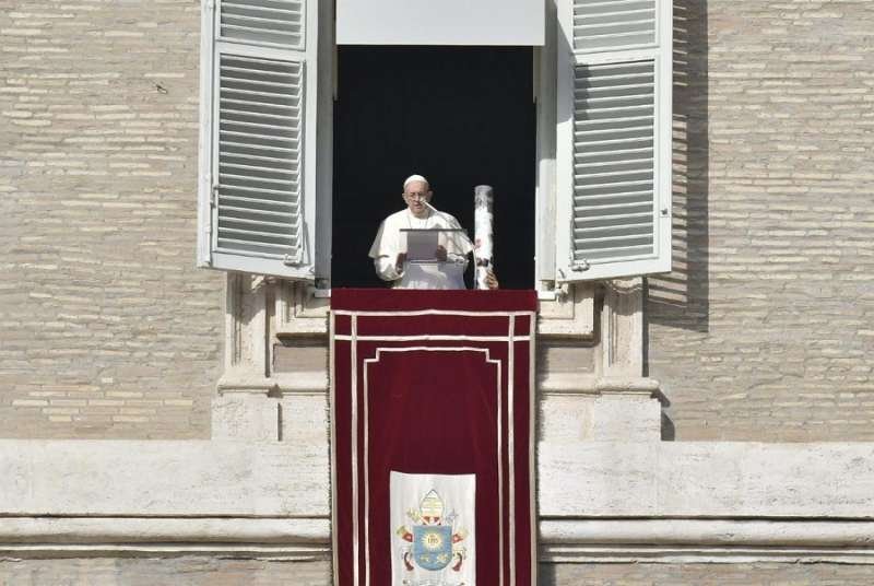 Pope Francis lights a candle for Syria during the Angelus Dec. 2